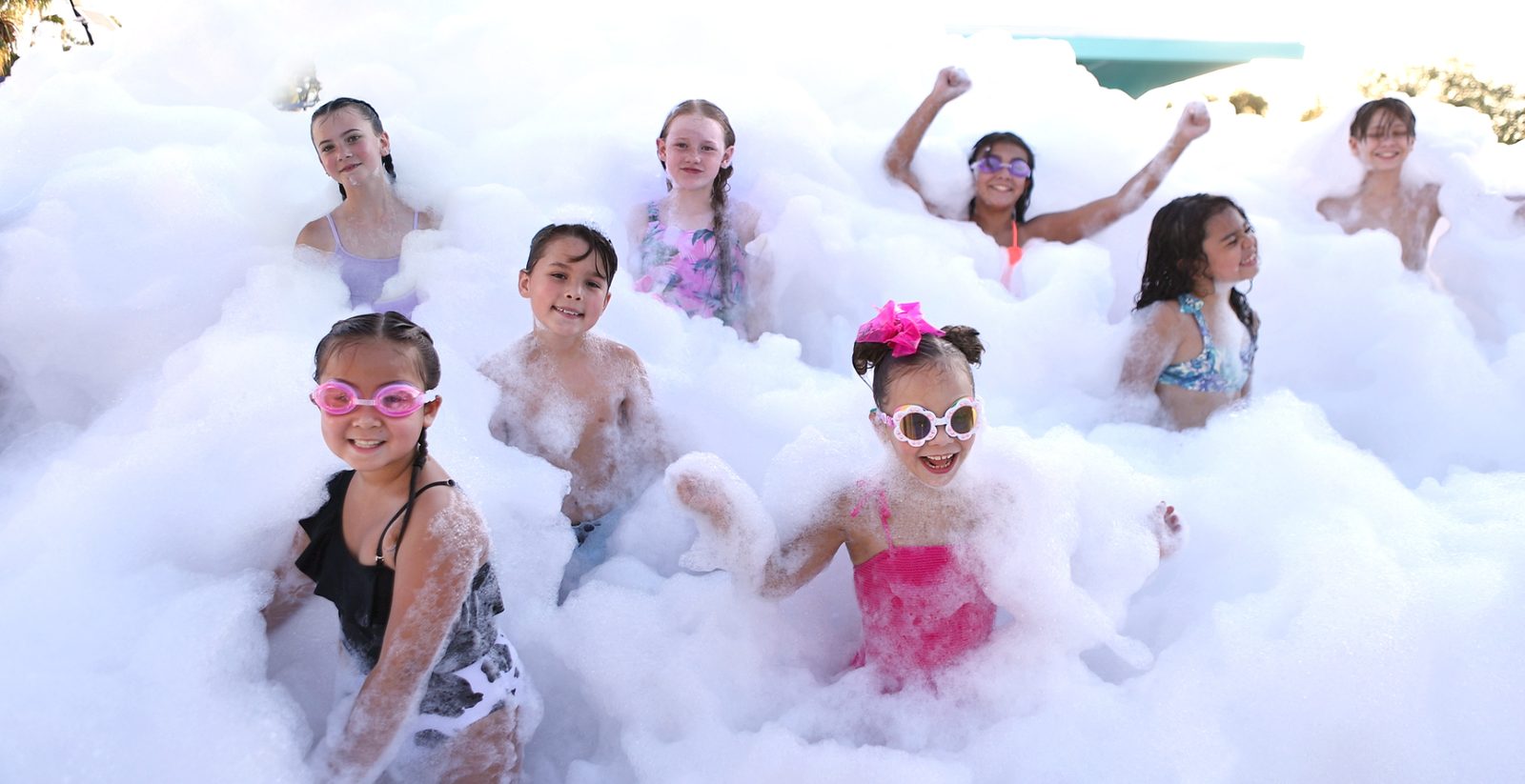 Large group of kids playing in deep foam at an event