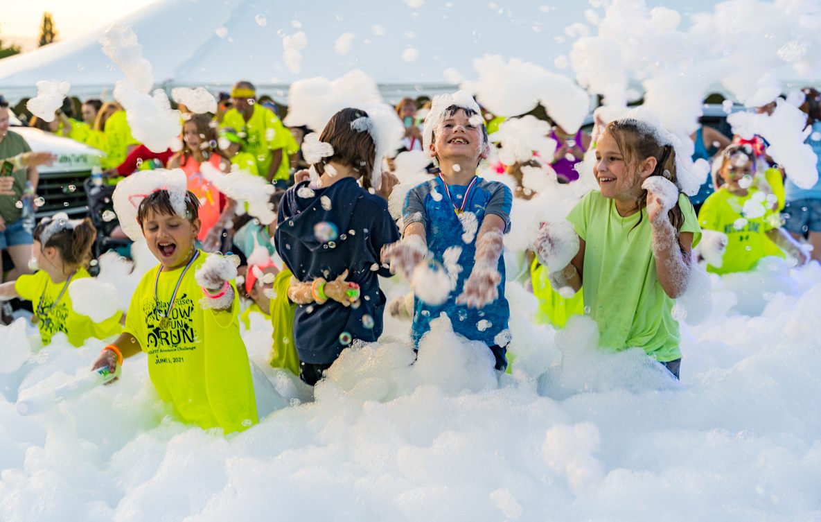 Kids celebrating in foam at a school fun run
