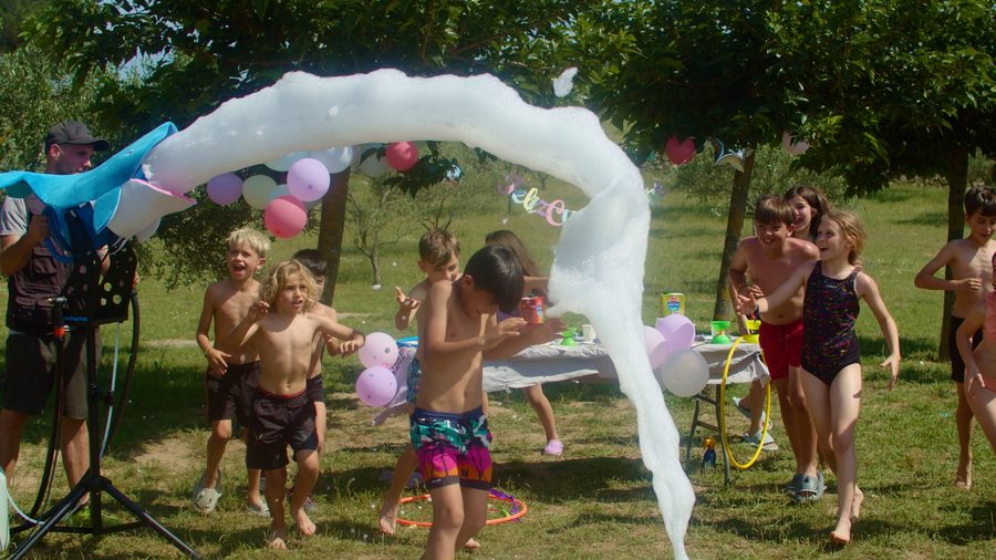 Kids playing under a foam arch at a birthday party