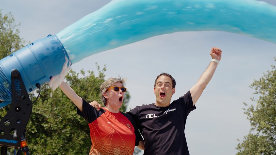 Adults celebrating under a foam cannon blast at a corporate event